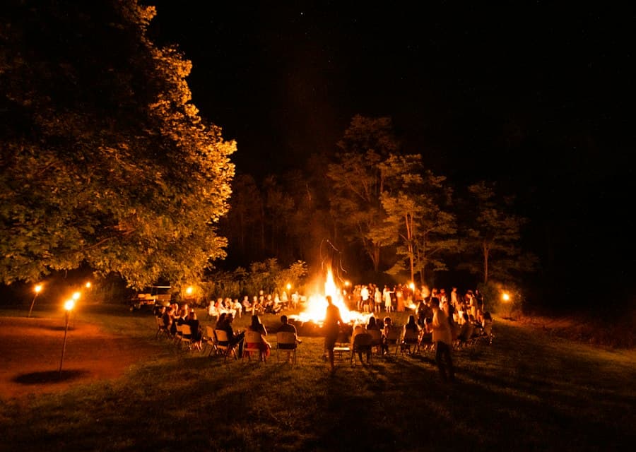 Menschen versammeln sich abends um ein Lagerfeuer